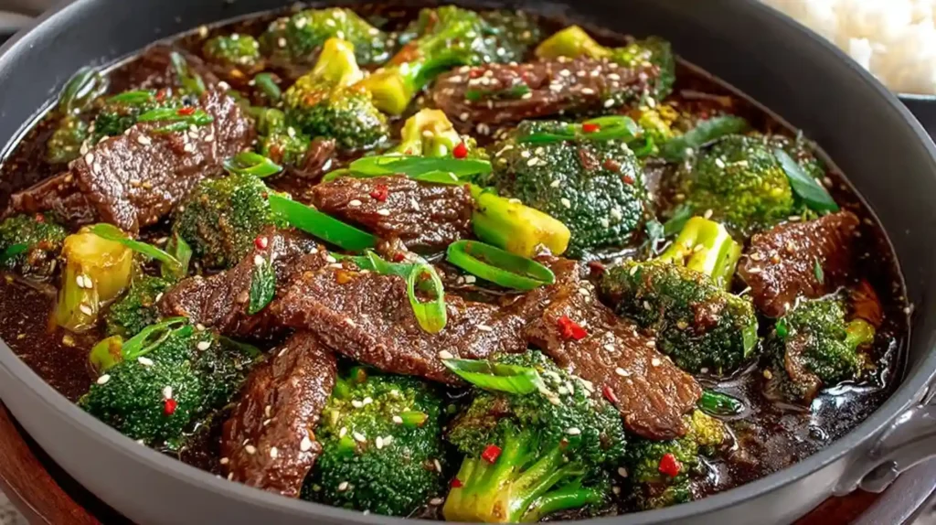 Better-than-takeout beef with broccoli in black wok with glossy dark soy oyster sauce glaze, one pound cornstarch-velveted flank steak strips, bright crisp-tender broccoli florets, minced garlic, and ginger ready in 20 minutes