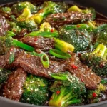 Better-than-takeout beef with broccoli in black wok with glossy dark soy oyster sauce glaze, one pound cornstarch-velveted flank steak strips, bright crisp-tender broccoli florets, minced garlic, and ginger ready in 20 minutes