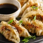 Crispy golden Frozen Dumplings in Air Fryer potstickers gyoza cooked at 375°F for 8 minutes with oil spray soy sauce and fresh green onions
