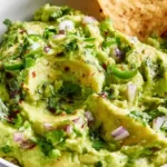 Homemade guac cart guacamole served in a rustic bowl with tortilla chips and fresh lime wedges