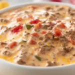Rotel dip with ground beef classic 3-ingredient Velveeta party appetizer 20 minutes โ brown 1 pound lean ground beef large skillet medium-high heat crumbled cooked 6-8 minutes no pink drained, reduce heat medium-low cubed 16-ounce Velveeta added entire 10-ounce can Rotel tomatoes with liquid undrained poured stirred melted smooth creamy 5-7 minutes, optional 1 tablespoon taco seasoning or chili powder added while beef cooking extra flavor, served warm tortilla chips slow cooker warm setting keeps melty hours