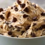 Greek Yogurt Cookie Dough in a bowl with creamy beige dough chocolate chips and a spoon for a high-protein no-bake treat