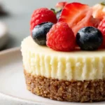 Easy Mini Cheesecake Recipe with individual mini cheesecakes in a muffin tin topped with strawberry sauce cherry topping whipped cream and fresh berries