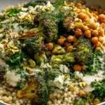Warm Broccoli Couscous Salad with roasted broccoli couscous chickpeas fresh herbs pistachios and feta in a large serving bowl